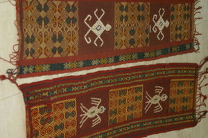 Hand woven ceremonial Sumba Hinggi Ikat Songket Textile 55"x 13.25" Geometric Designs. Handspun Cotton Tapestry, Dyed with Natural Pigments. Adorned with Symbolic Insect Motifs Created with Hand sewn tiny Nassa Shells (SR26) red rust background
